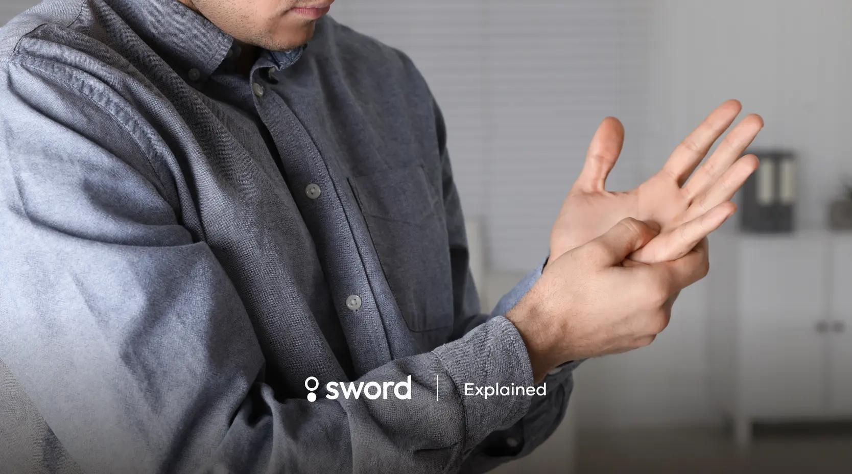 Person in a gray shirt massaging their hand, possibly due to discomfort. Text reads "sword Explained" at the bottom.