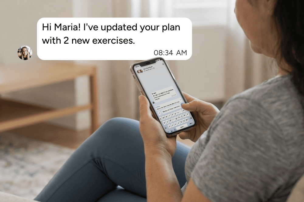 A woman sitting on a couch holds a smartphone, reading a message that says, Hi Maria! Ive updated your plan with 2 new exercises. The time is 08:34 AM.