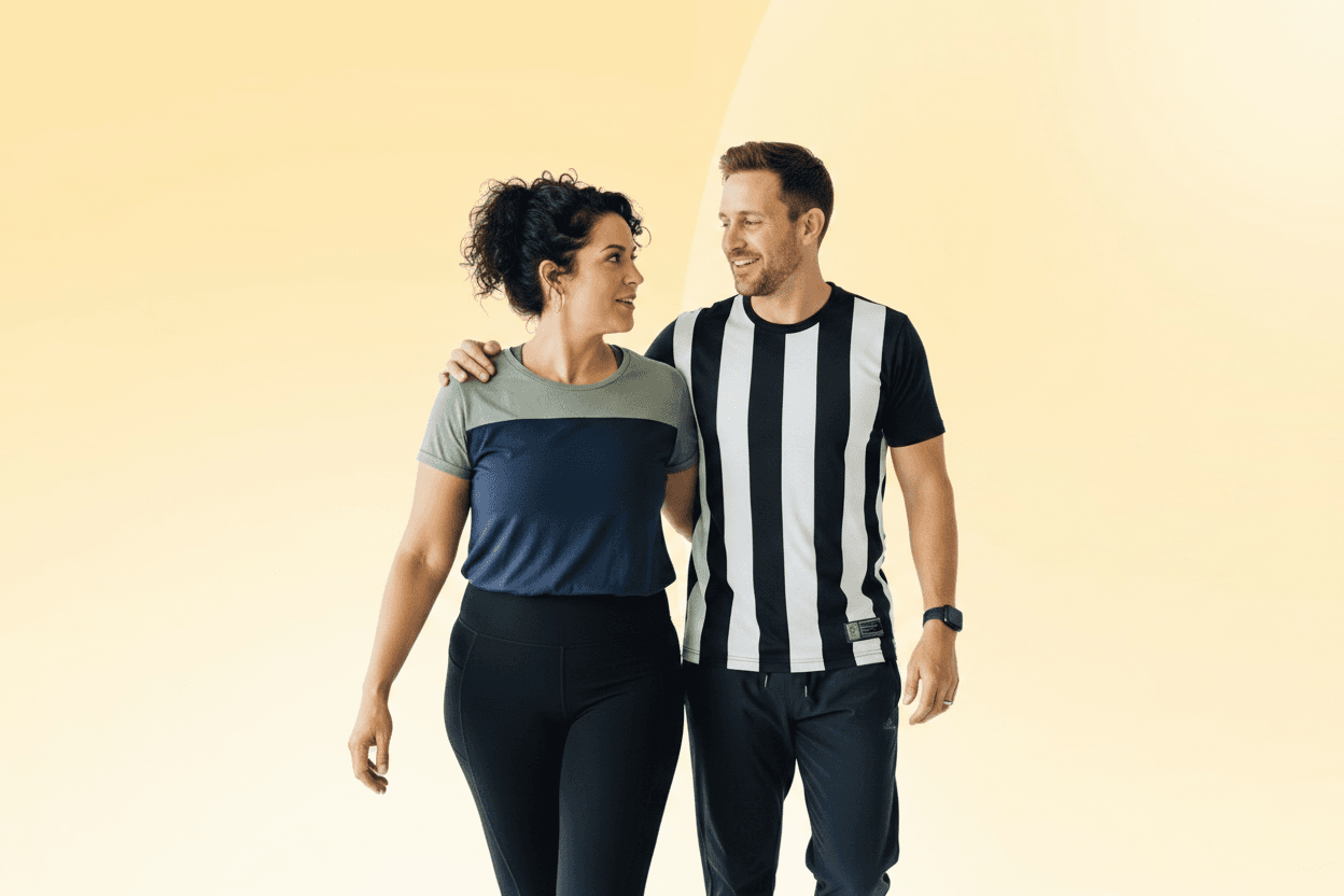 A man and woman smiling at each other while walking, with a light yellow background. The woman wears a blue shirt, and the man wears a striped shirt.