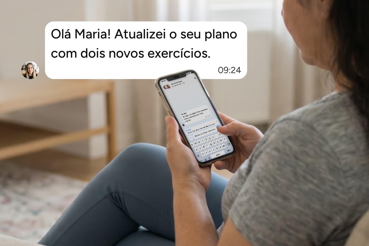 Mulher sentada em um sofá segurando um celular e lendo uma mensagem que diz: Olá Maria! Atualizei o seu plano com dois novos exercícios.