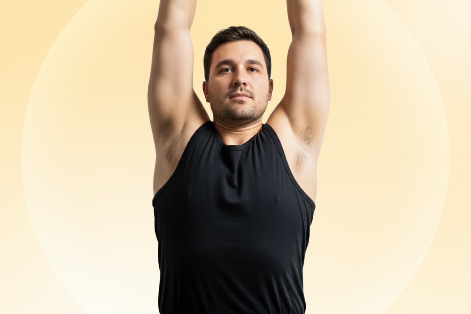A person in a black tank top stretches upward against a soft yellow background, appearing focused and calm.