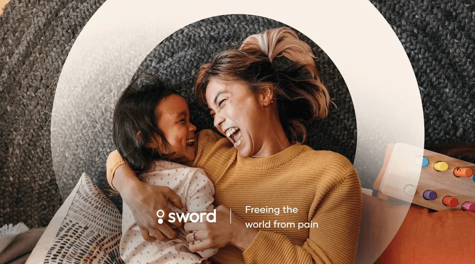 A woman and child laughing together on a couch, with the text "Sword: Freeing the world from pain" overlayed on the image.