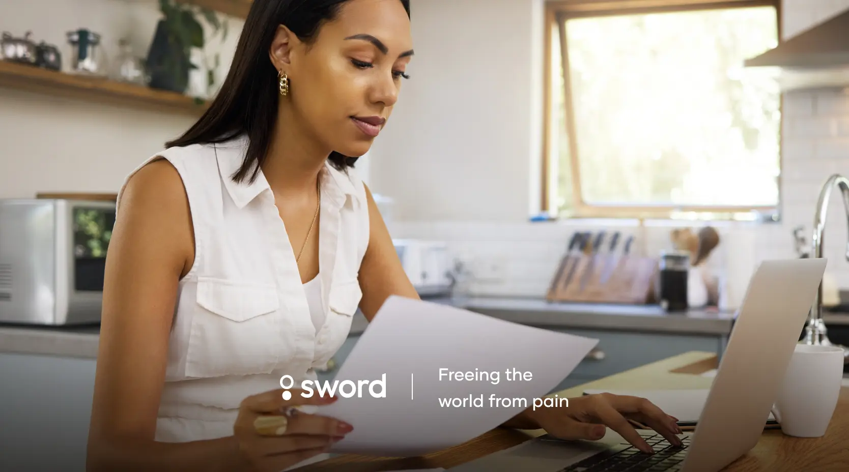 Woman in a kitchen reading a document with a laptop open, next to the text "Sword: Freeing the world from pain."