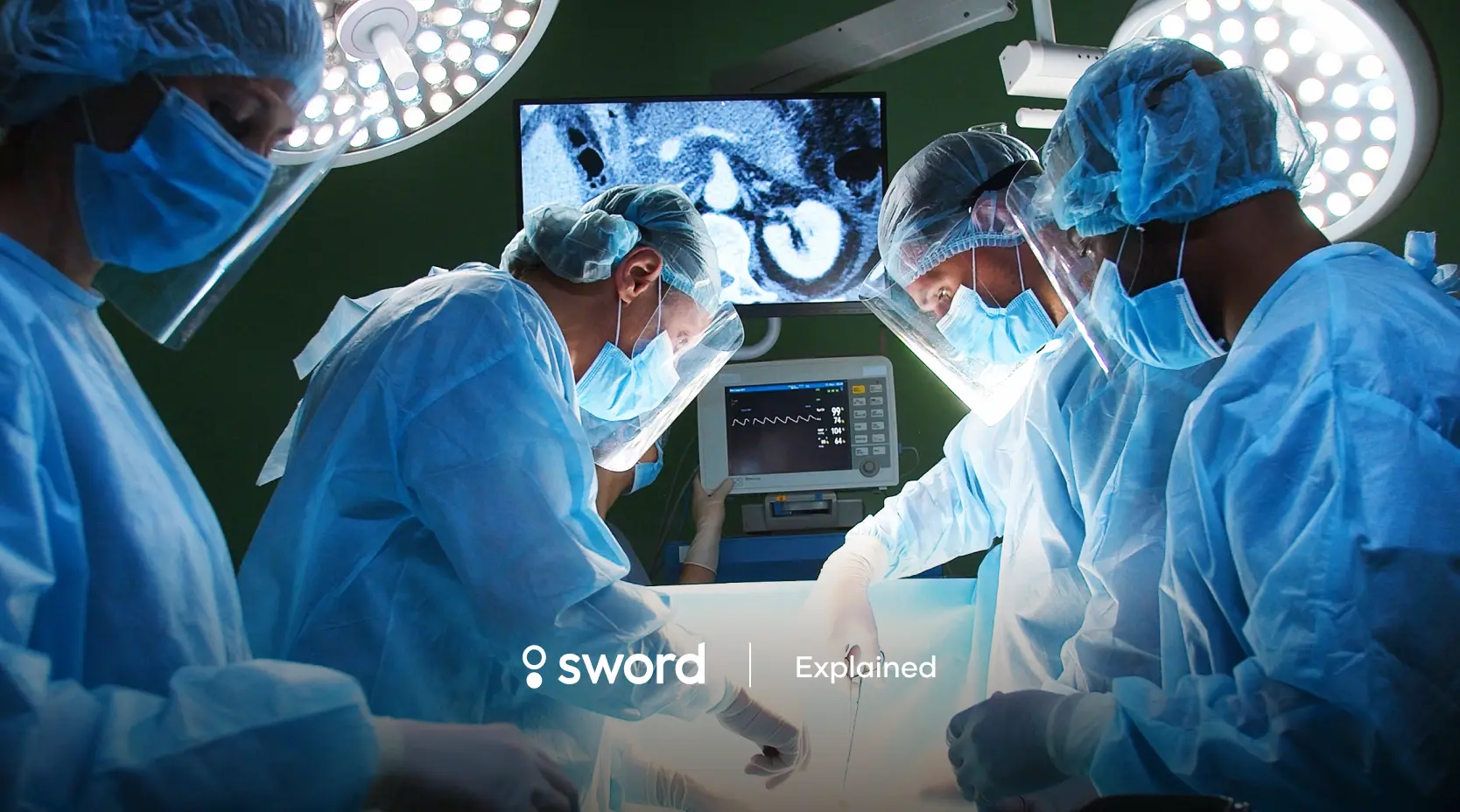 Surgeons in blue scrubs and masks perform surgery under bright lights, with a monitor displaying medical images in the background.