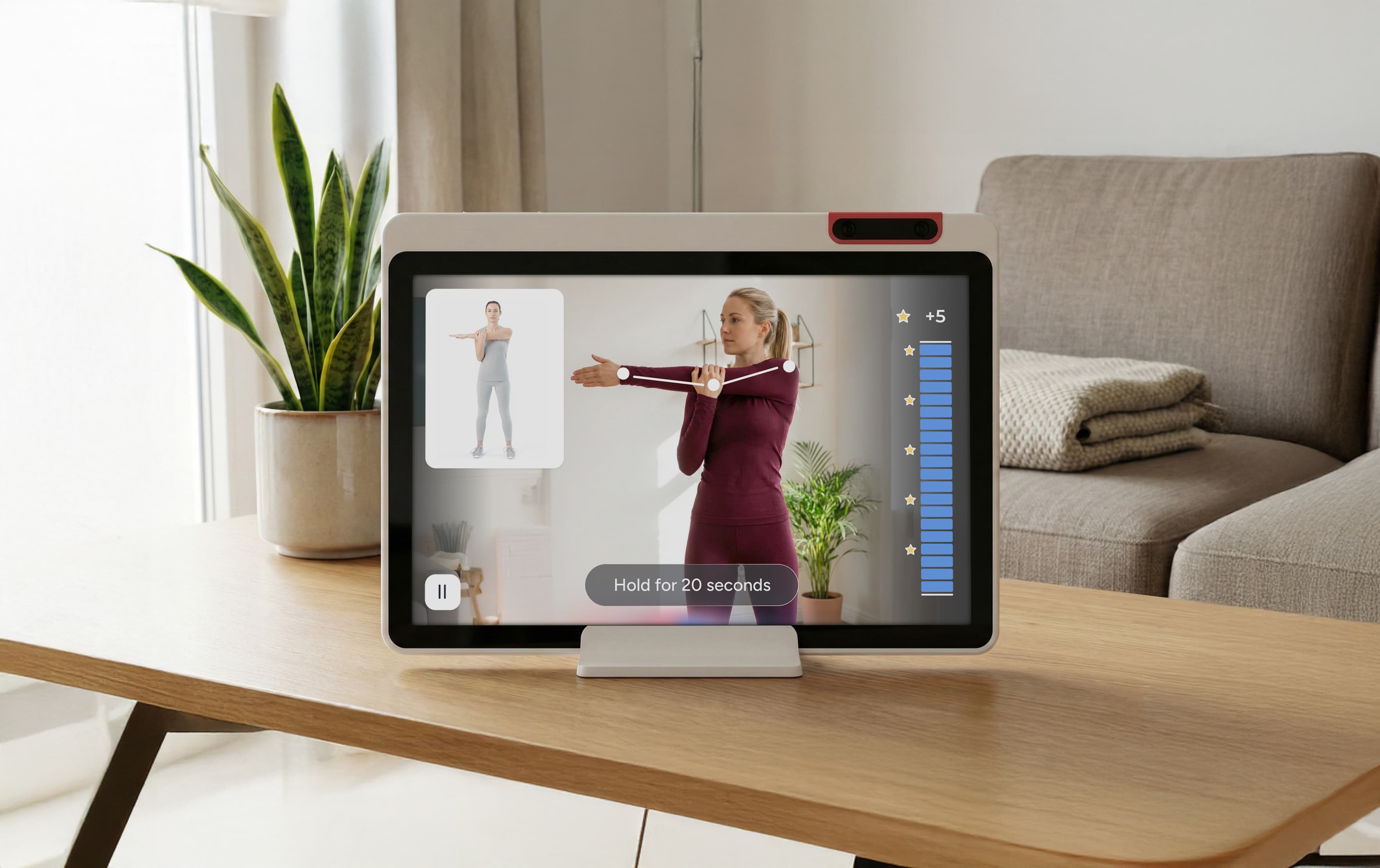 A tablet on a wooden table displays a woman leading a virtual exercise class in a living room, with a stretch pose timer, points, and progress bar visible on the screen.